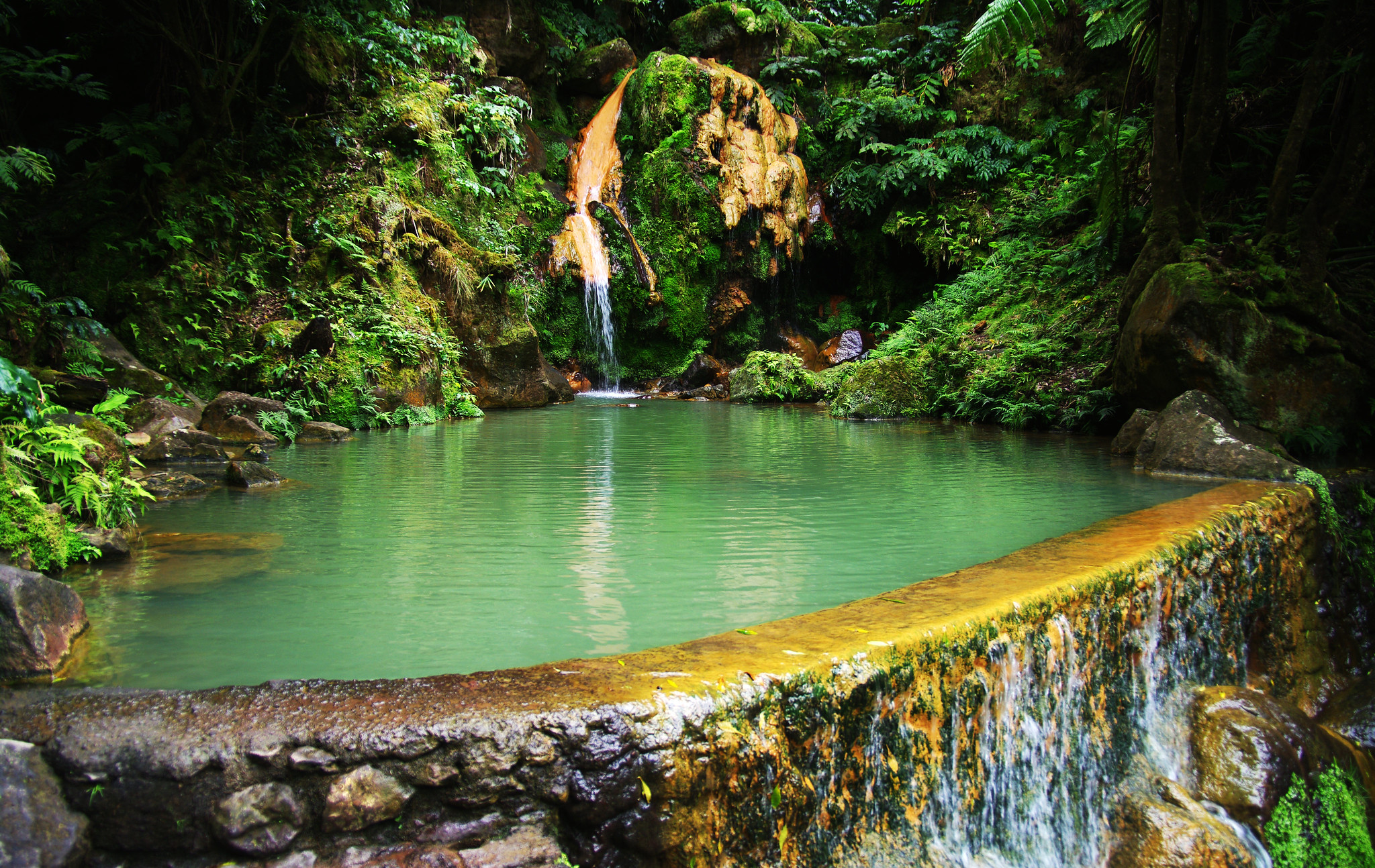 Piscinas termales naturales en Caldeira Velha, Azores, un lugar para relajarse en la naturaleza con seguro de viaje para Portugal.