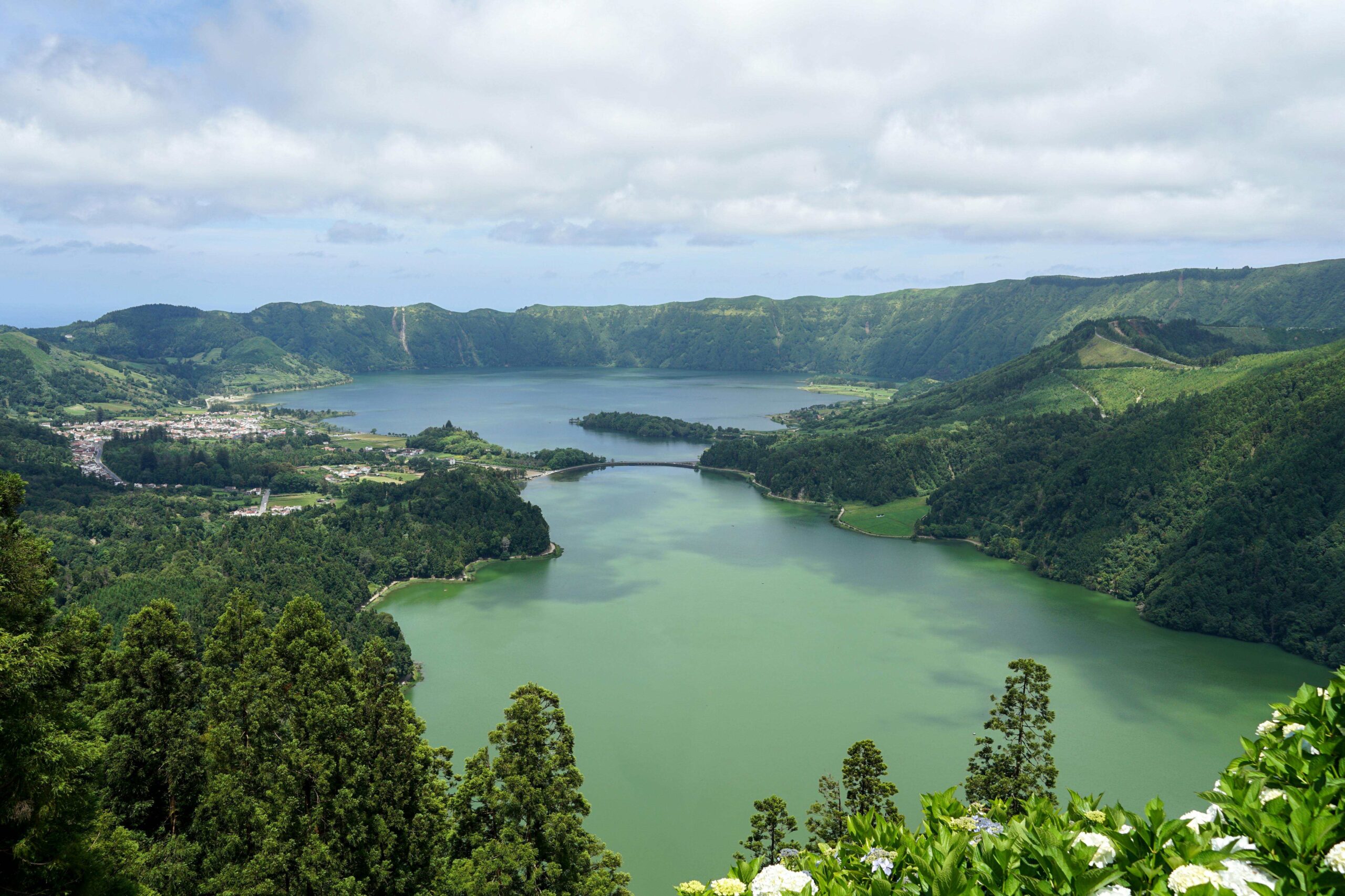 Vista panorámica de la Lagoa das Sete Cidades en Azores, un cráter volcánico con lagos azul y verde. Seguro de viaje Portugal recomendado para explorar Azores.